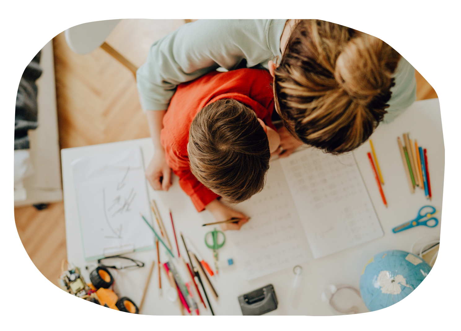 an overhead image of a mother helping her son with schoolwork
