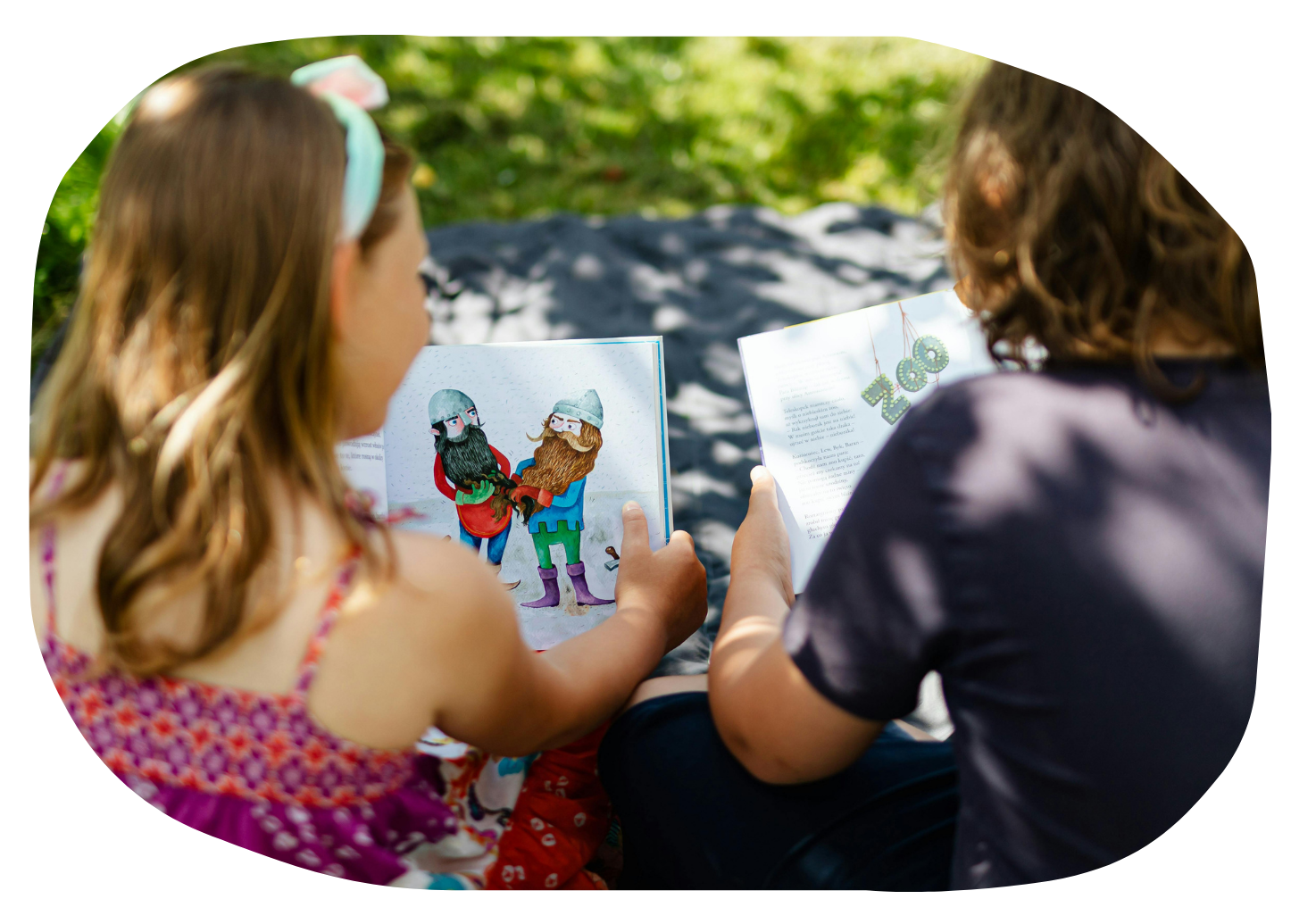 image looking over the shoulder of two children reading a book together